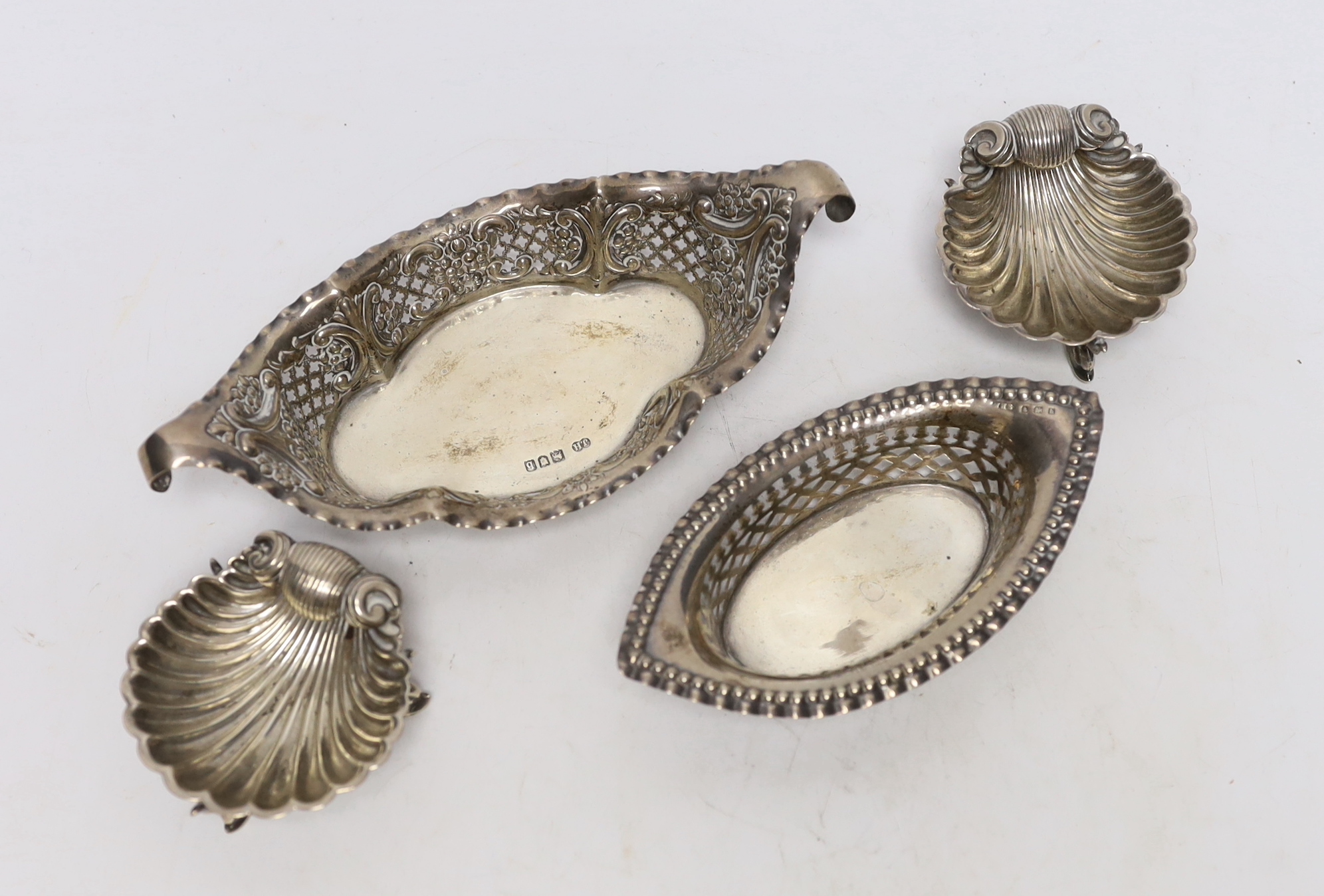 A pair of Victorian silver shell salts, on dolphin supports, London, 1876, 69mm and a two pierced silver bonbon dishes.